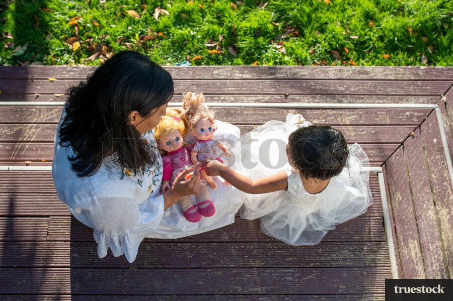 Mother and Daughter Playing with Dolls Outside