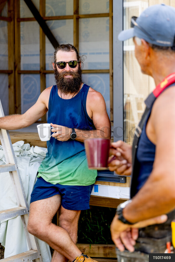 Builder and electrician taking break on construction site