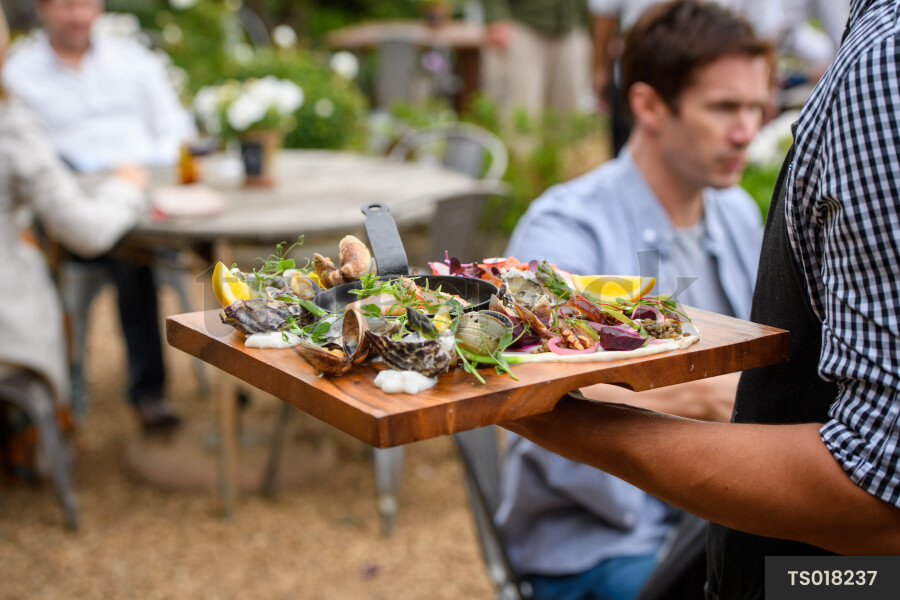 Waiter serving oysters at restaurant