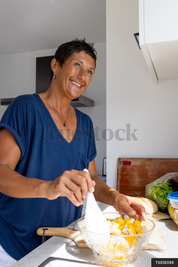 Smiling woman cooking in kitchen