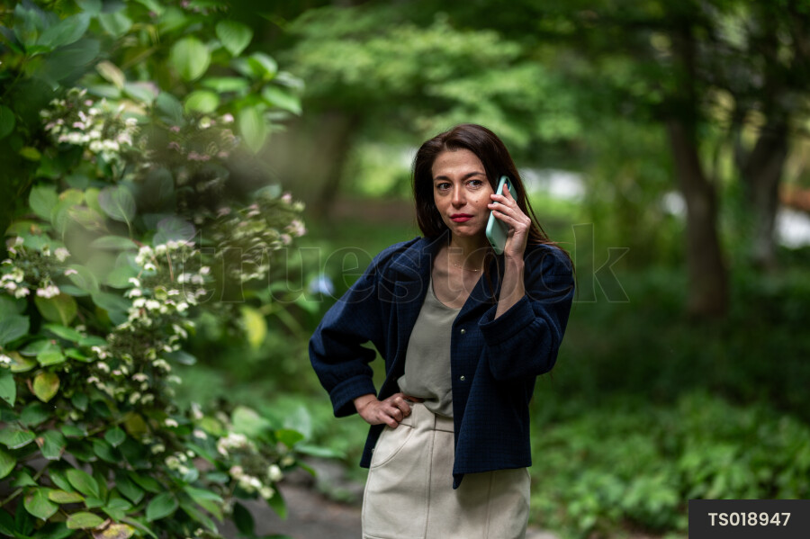 Young woman with smart phone in park