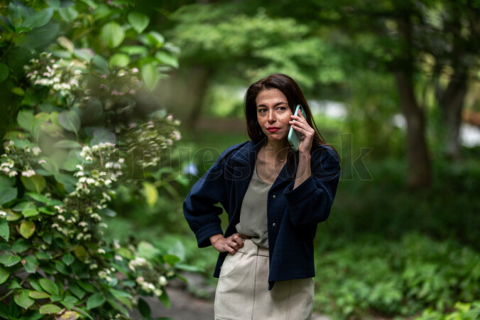 Young woman with smart phone in park