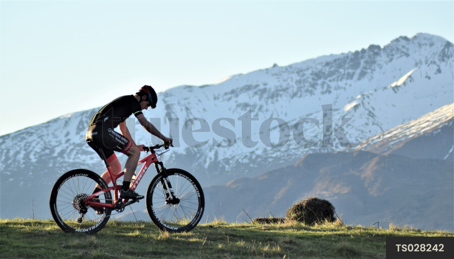 Man mountain biking by mountain