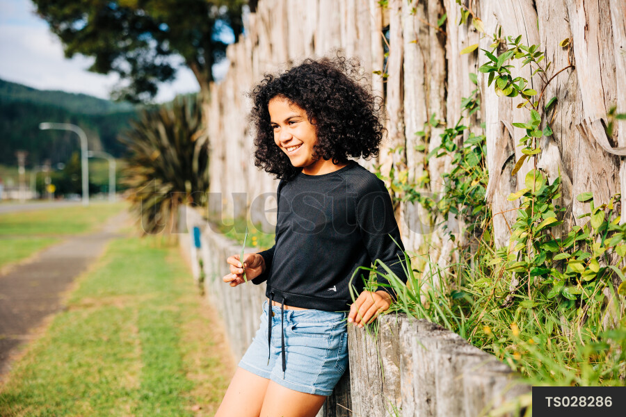 Young Girl in Front of Fence