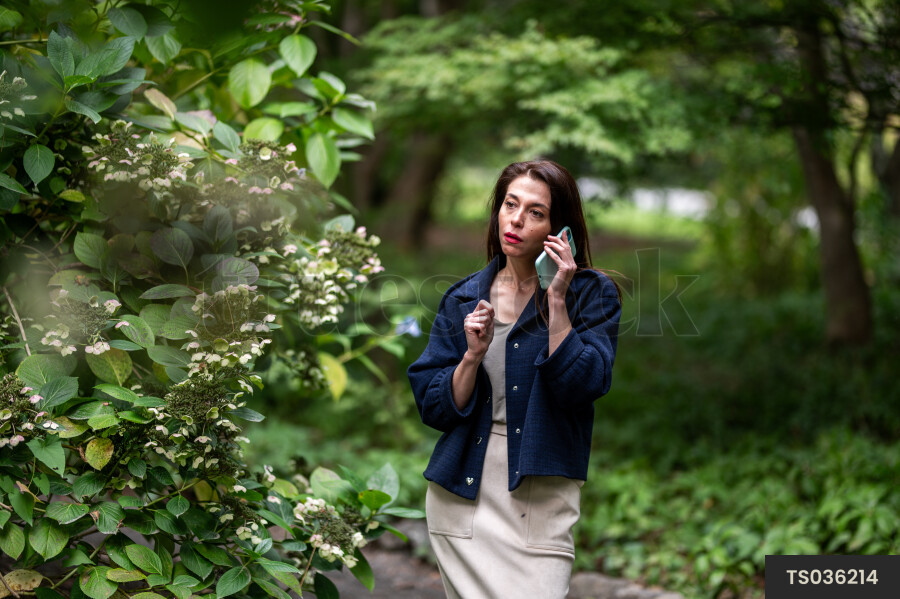 Young woman with smart phone in park