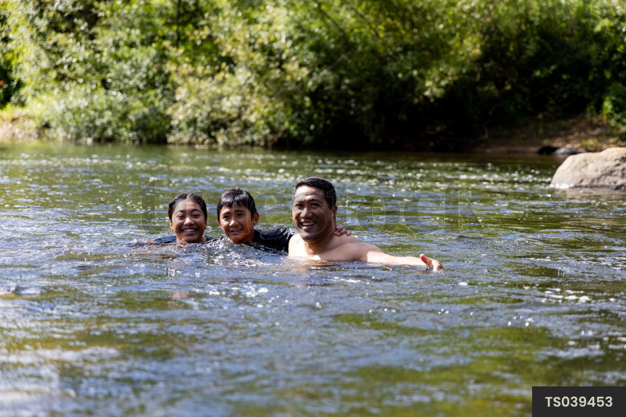Family swimming in river