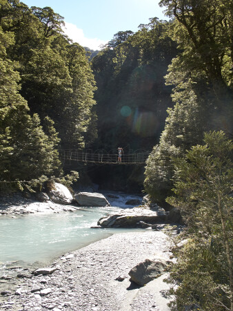 Man hiking on bridge in Matukituki Valley