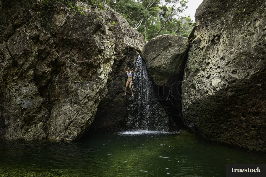 Woman Jumping off Rocks into the Water