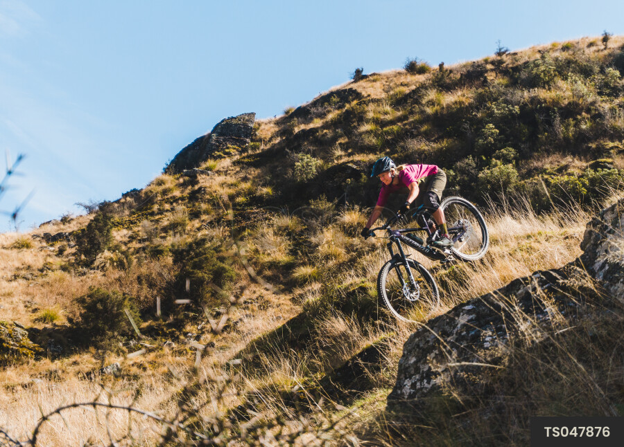 Woman mountain biking on mountain in South Island
