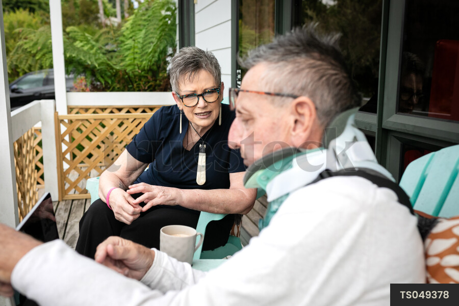 Health carer sitting with patient on deck