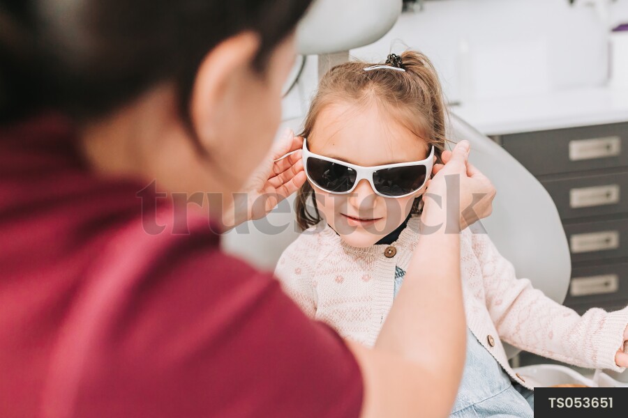 Dentist with sunglasses of patient in dental clinic