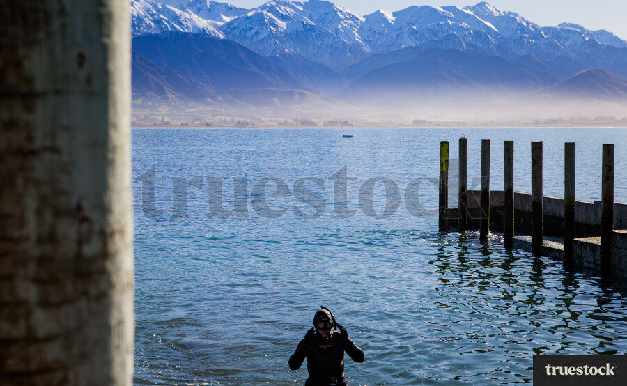 Diver wearing a snorkel in the lake by the mountain ranges