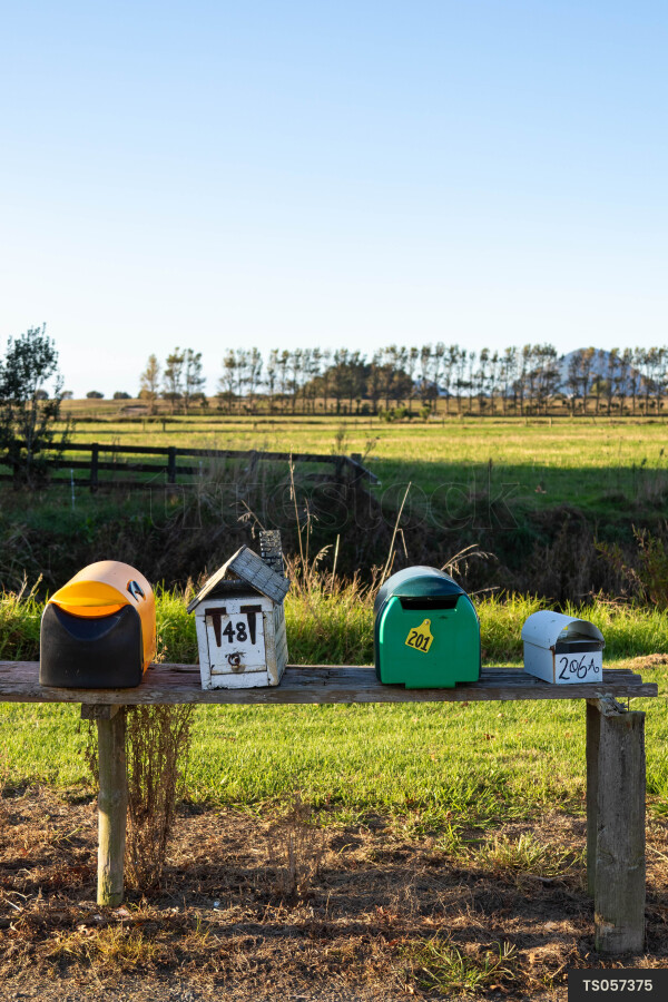 Postboxes on wood by field in countryside