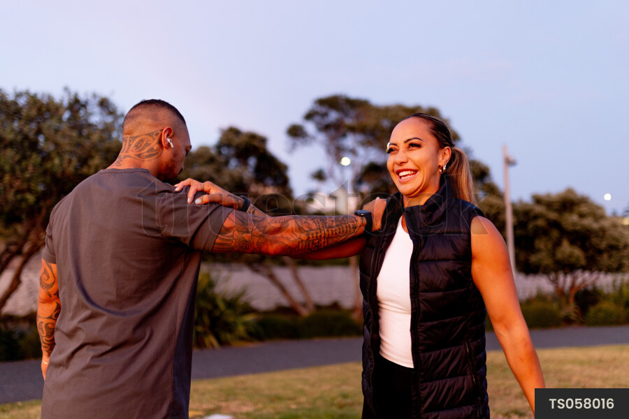 Couple stretching in park