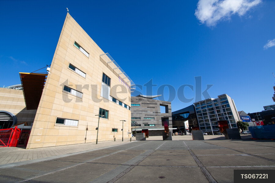 Urban scene of buildings next to sidewalk in city