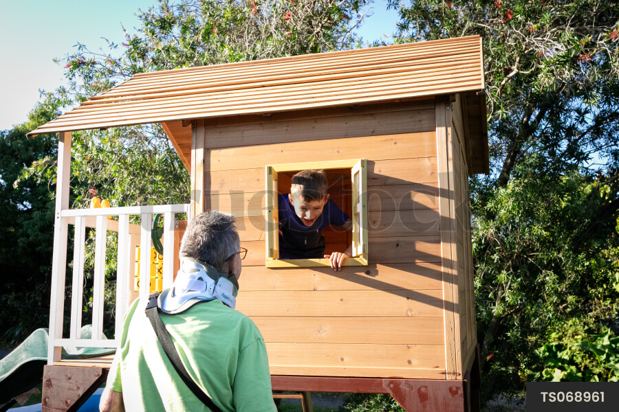 Man playing with grandson in playhouse