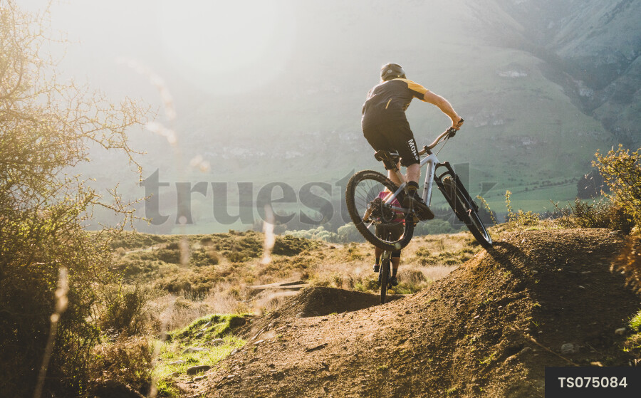 Men mountain biking on dirt trail