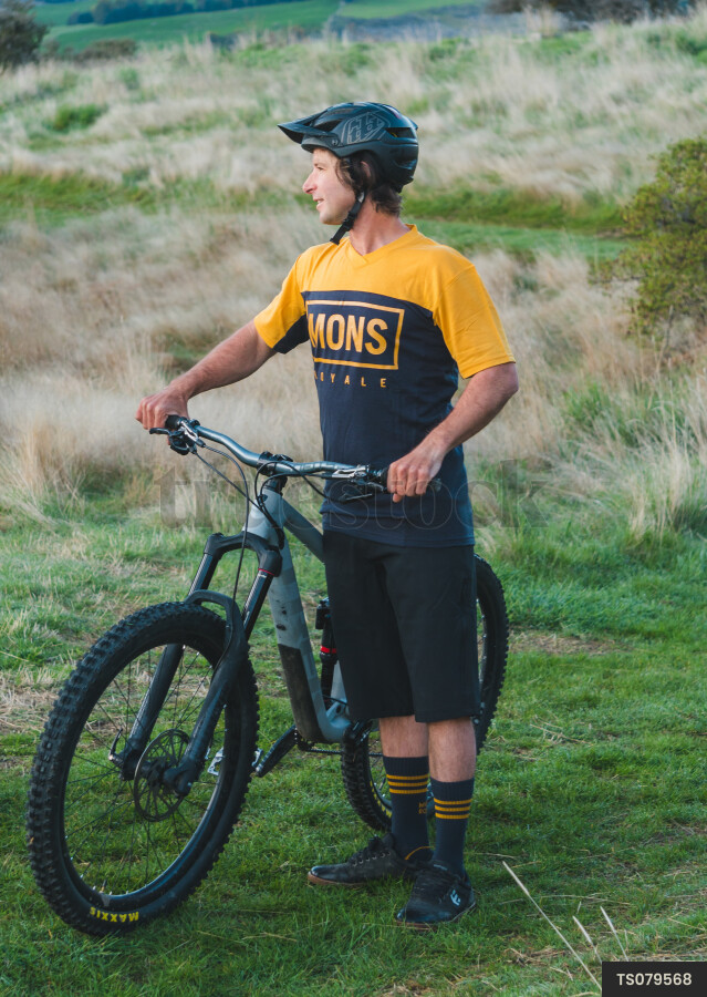 Man with mountain bike and helmet in field
