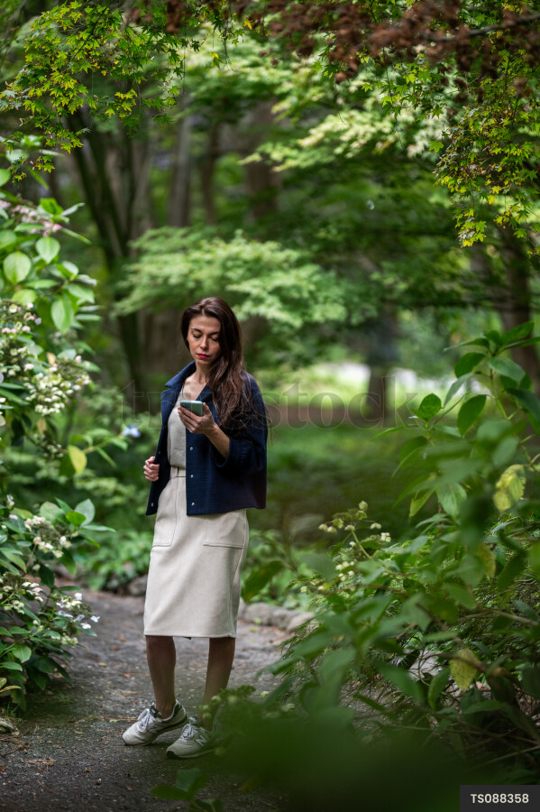 Young woman with smart phone in park