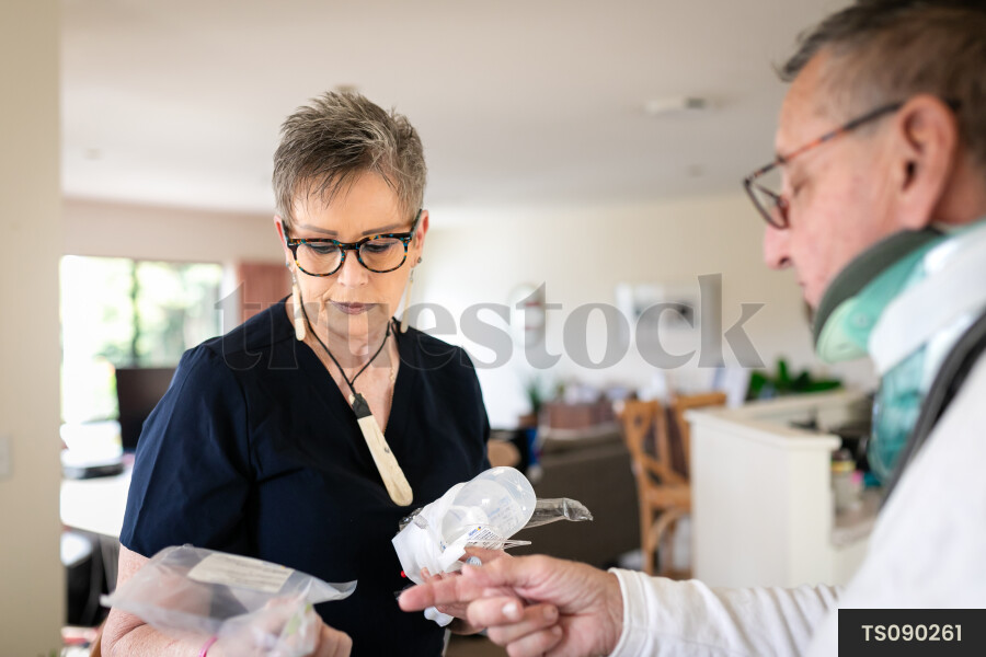 Health carer helping patient with neck brace
