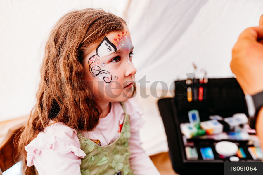 Girl with creative face painting at kids party