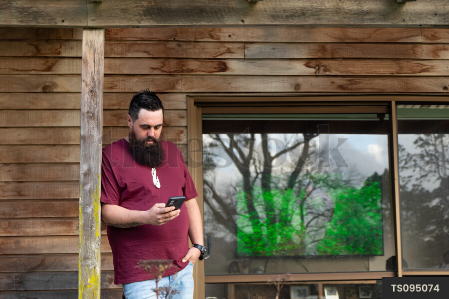 Man Using Phone on Porch