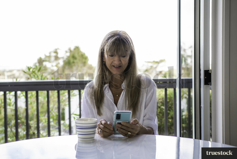 Woman on Phone at Kitchen Table