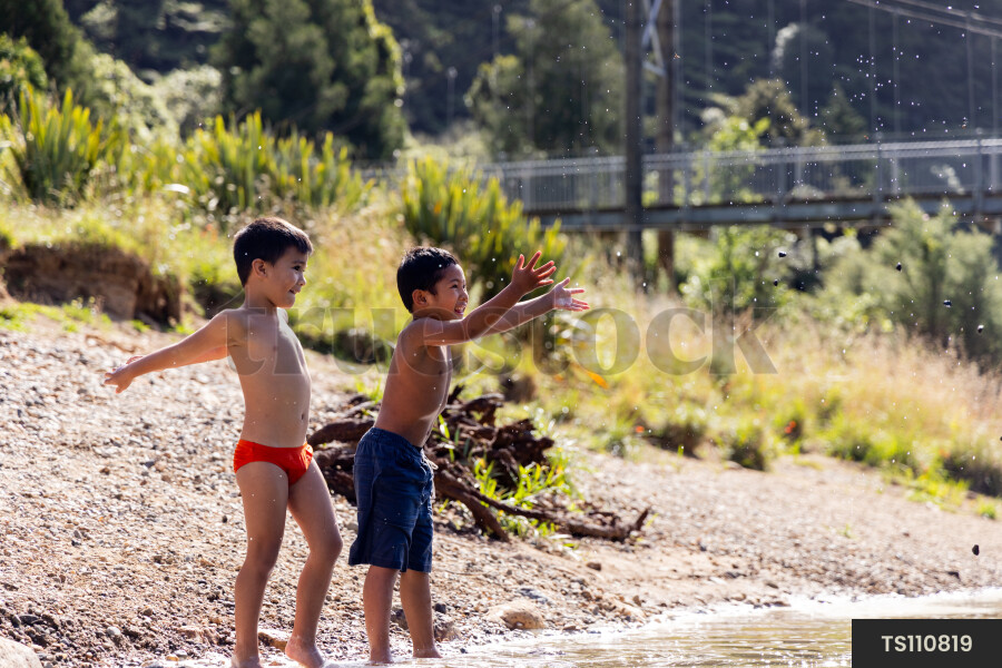 Boys playing on riverbank