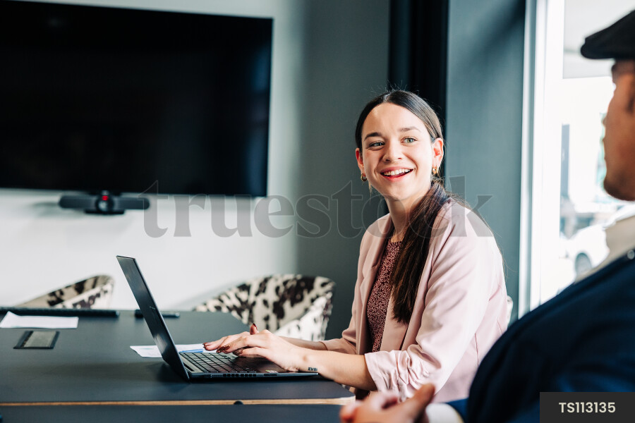 Businesspeople with laptop during meeting in boardroom
