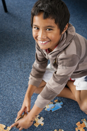 Young Boy Doing a Puzzle in Class
