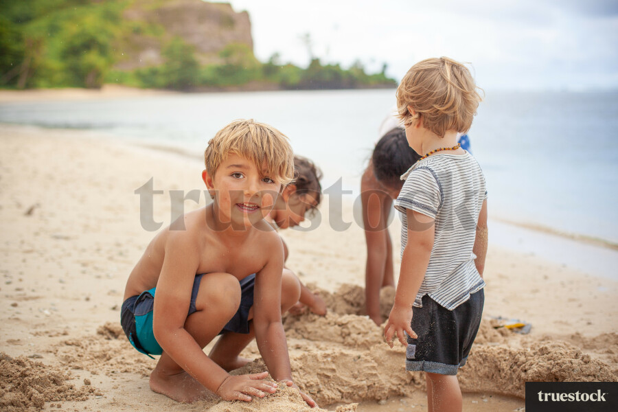 Children playing and creating in the sand at the beach