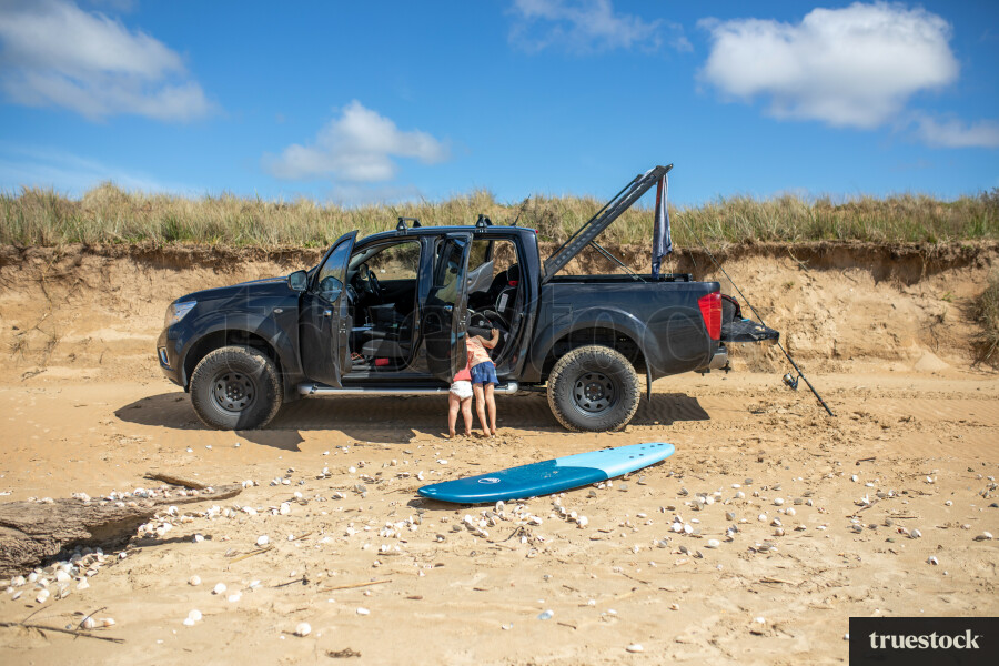 Sisters Looking in Truck at Beach