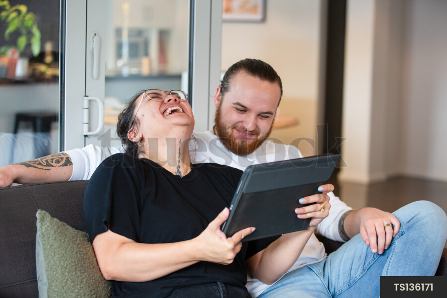 Couple Using iPad on Couch