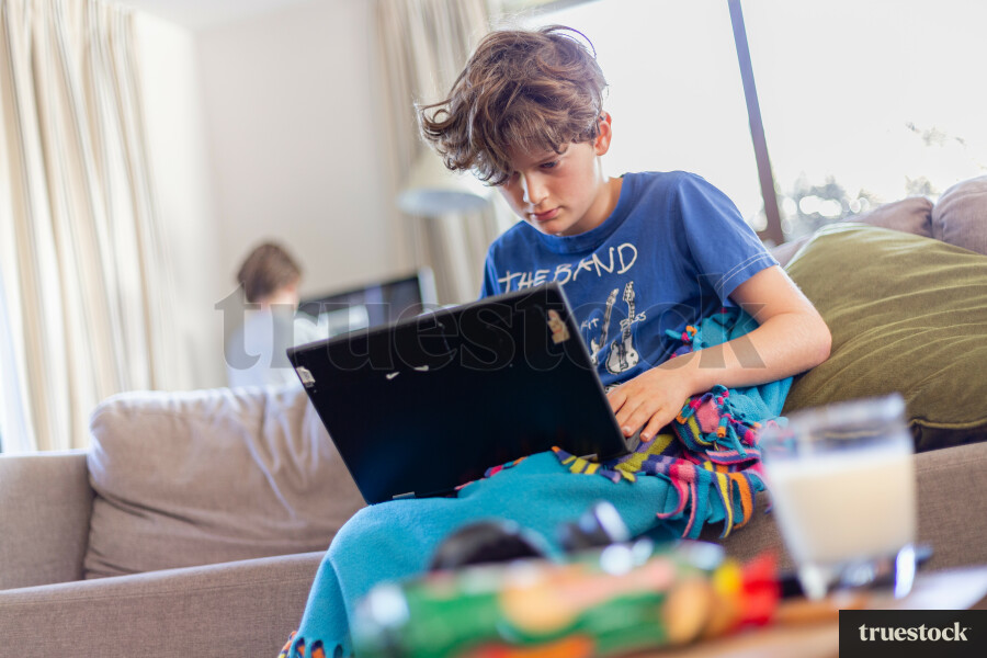 Child doing schoolwork on the couch