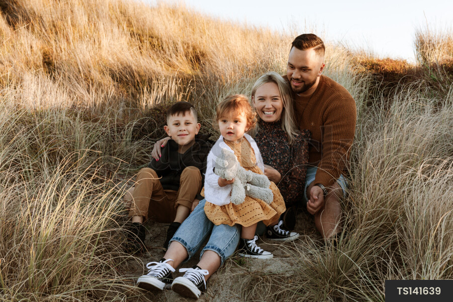 Family sitting on sand dunes