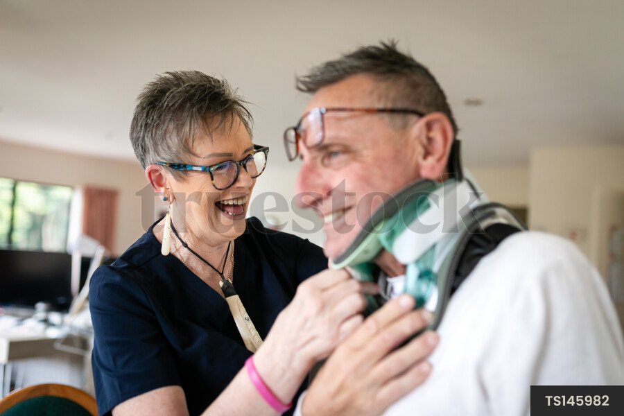 Health carer helping patient with neck brace