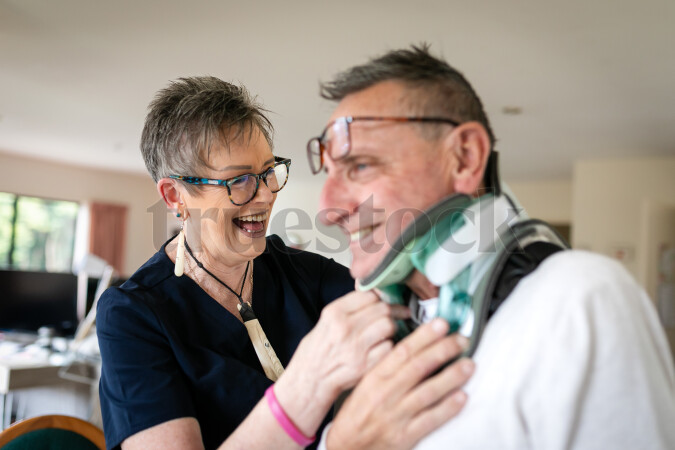 Health carer helping patient with neck brace