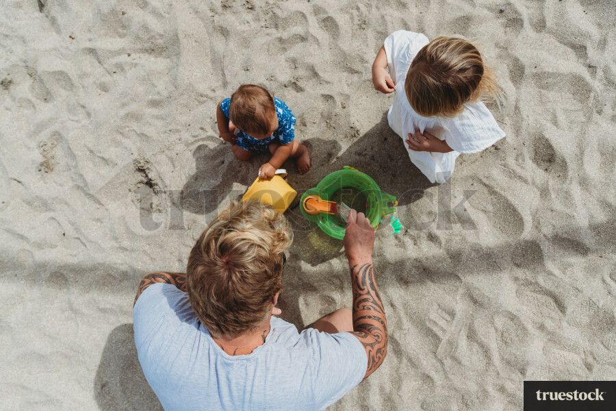 Father Building Sandcastle with Children