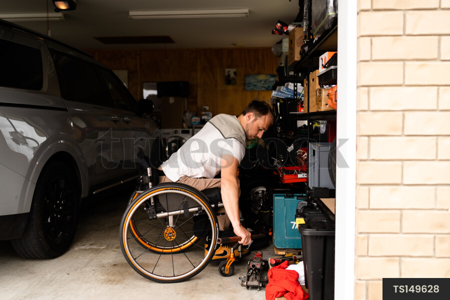 Man in wheelchair doing DIY in garage