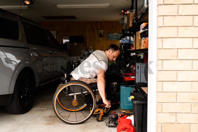 Man in wheelchair doing DIY in garage