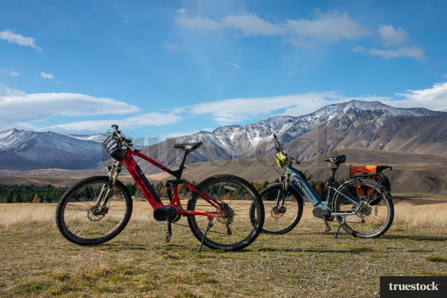 Two Bikes on Grass with Mountain Landscape