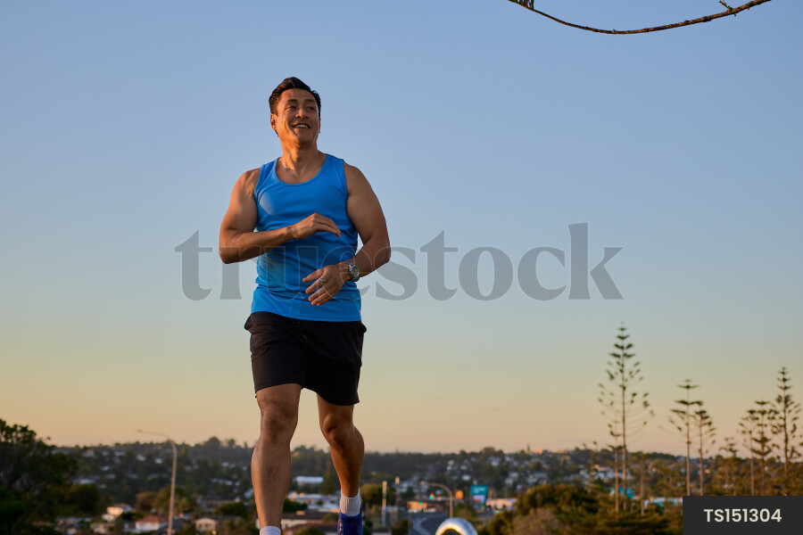 Togan man smiling while running during sunset