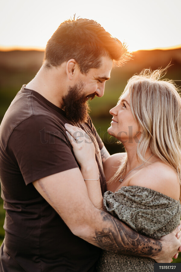 Couple embracing in countryside during sunset