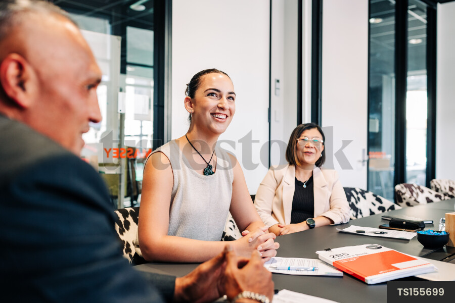 Businesspeople smiling during meeting in boardroom