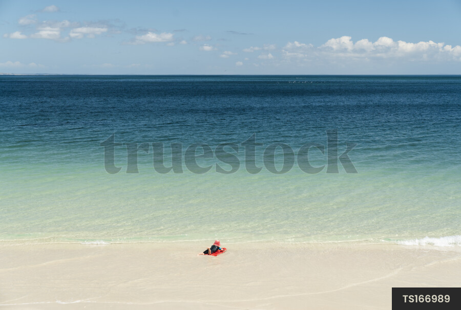 Boy playing with boogie board at beach