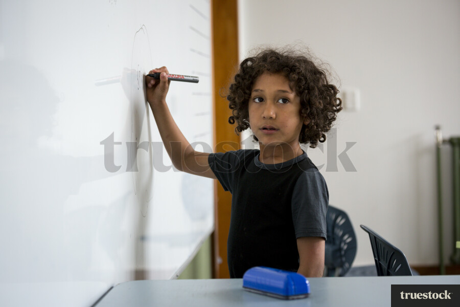 Kid Writing on the Whiteboard at School