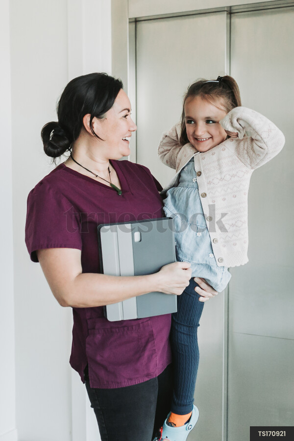 Dentist carrying patient by elevator in clinic