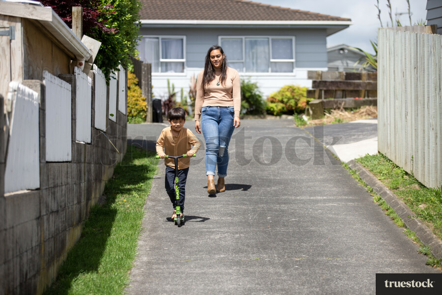 Son Riding Scooter in Driveway