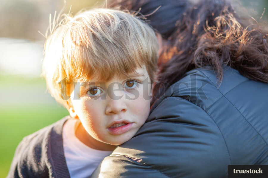 Mother giving shocked son a hug