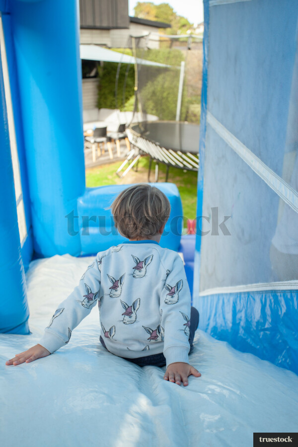 Child climbing and bouncing in the inflatable bouncy castle